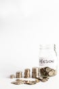 Coins stacked up next to an empty jar with a label on for pension fund. Pension, financial, savings, economy, investment concept Royalty Free Stock Photo