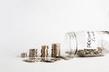 Coins stacked up next to a half empty jar with coins in and with a label on saying pension fund. Pension, financial, savings, Royalty Free Stock Photo