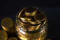 Coins stacks and gold coin money in the glass jar on dark background, for saving for the future banking finance concept. Royalty Free Stock Photo