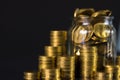 Coins stacks and gold coin money in the glass jar on dark background, for saving for the future banking finance concept. Royalty Free Stock Photo