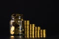 Coins stacks and gold coin money in the glass jar on dark background, for saving for the future banking finance concept. Royalty Free Stock Photo