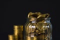 Coins stacks and gold coin money in the glass jar on dark background, for saving for the future banking finance concept. Royalty Free Stock Photo