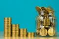 Coins stacks and gold coin money in the glass jar on table with Royalty Free Stock Photo