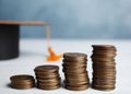 Coins and student graduation hat on wooden table. Tuition fees concept Royalty Free Stock Photo