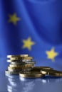 Coins on table against European Union flag, closeup. Space for text Royalty Free Stock Photo