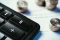 Coins are on the table on the documents and next to the calculator. Money and finance concept.