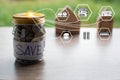 Coins and text SAVE in a glass jar placed on a wooden table. Concept of saving money for investment and buy a home