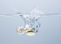 Coins in the water. Splash of coins falling into the water Royalty Free Stock Photo