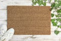 Coir doormat mockup with green plant decoration on white wooden background