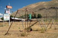 Swingset and playground at an old abandoned seedy motel, with overgrown weeds in the parking