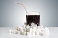 Cola drink in glass and many sugar cubes around. Unhealthy eating concept Royalty Free Stock Photo