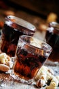 Cola glasses, sweet and savory snacks, old wooden table, unhealt