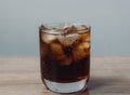 Cola and ice cube in clear glass on wooden table Royalty Free Stock Photo