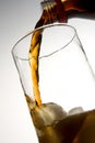 Cola pouring into glass with ice Royalty Free Stock Photo