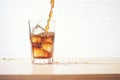 cola pouring over ice cubes in a glass cup Royalty Free Stock Photo