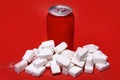 Cola refreshing drink can and lot of white sugar cubes represent