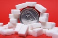 Cola refreshing drink can and lot of white sugar cubes representing the big amount of calories Royalty Free Stock Photo