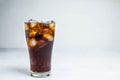 .Cola soda in a glass on a white table