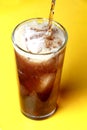 Cola soda poured into a glass with ice cubes Royalty Free Stock Photo
