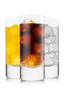Cola soft drink with orange soda and lemonade with ice cubes on white in highball glasses Royalty Free Stock Photo