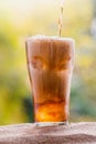 Cola water pouring into glass with ice cubes on sand Royalty Free Stock Photo