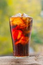 Cola water pouring into glass with ice cubes on sand Royalty Free Stock Photo