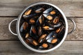 Colander with delicious cooked mussels on wooden table, top view