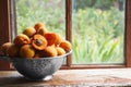 Colander with delicious ripe apricots on wooden table near window. Space for text