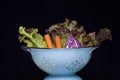 Colander filled with Salad Veggies.