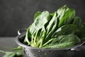 Colander with fresh green healthy spinach on table