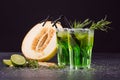 Cold alcohol cocktails. Two glasses of green drinks with tarragon. A sweet cut lemon and sour lime. Alcoholic summer cocktails. Royalty Free Stock Photo