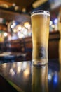 Cold alcohol drink on a table in a bar of pub. Vertical image. Selective focus. Cinematic tone. Drinking lager beer of cider