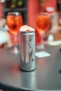 Cold aluminum can with alcoholic drink on table in an outdoor pub and light bokeh