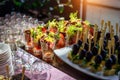 Cold appetizers at banquet, restaurant service, catering. Variety of delicious starters on wooden skewers and salads Royalty Free Stock Photo