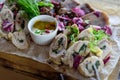 Cold appetizers of chicken and other meats, served on a wooden plate with mustard and horseradish sauce, close-up. Rolls of Royalty Free Stock Photo