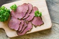 Cold beef in slices on a wooden board, view from above