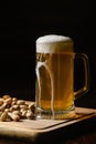 Cold beer with foam in a mug, on a wooden table and a dark background Royalty Free Stock Photo