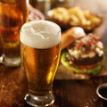 Cold beer with foamy head and burgers