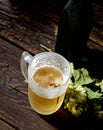 Cold beer in glass, bottle and hops on a dark wooden background Royalty Free Stock Photo