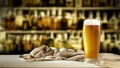 Cold beer in a glass on the table top with space and blurred background of bar. Blurred bottles view. Royalty Free Stock Photo