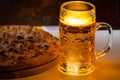 Cold beer in a glass tankard with Italian pizza