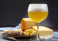 Cold belgian beer in glass served in cafe with variety of hard cheeses, tasty european food Royalty Free Stock Photo