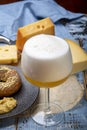 Cold belgian beer in glass served in cafe with variety of hard cheeses, tasty european food Royalty Free Stock Photo