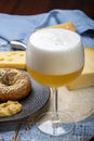 Cold belgian beer in glass served in cafe with variety of hard cheeses, tasty european food Royalty Free Stock Photo