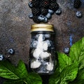 Cold berry drink in a bottle, square image, top view