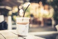 Cold beverage glass or cappuccino ice coffee on white wooden table at coffee shop