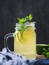 Cold beverage mojito in a glass jar with lime and mint