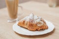 Cold black coffee with ice cubes in tall glass and fresh croissant. Royalty Free Stock Photo