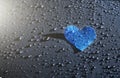 Cold blue heart on the raindrops background