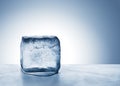 Cold blue ice block melting into water on metal surface Royalty Free Stock Photo